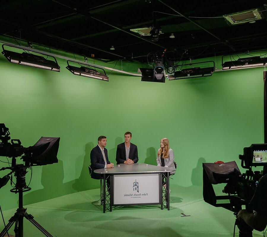 体育 broadcasting students present in front of a green screen.