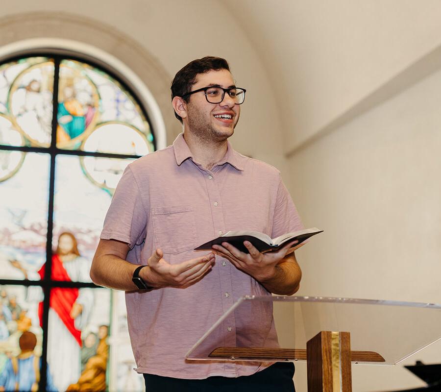 a student from the ministry 领导 studies concentration in pastoral ministries program reads from the bible